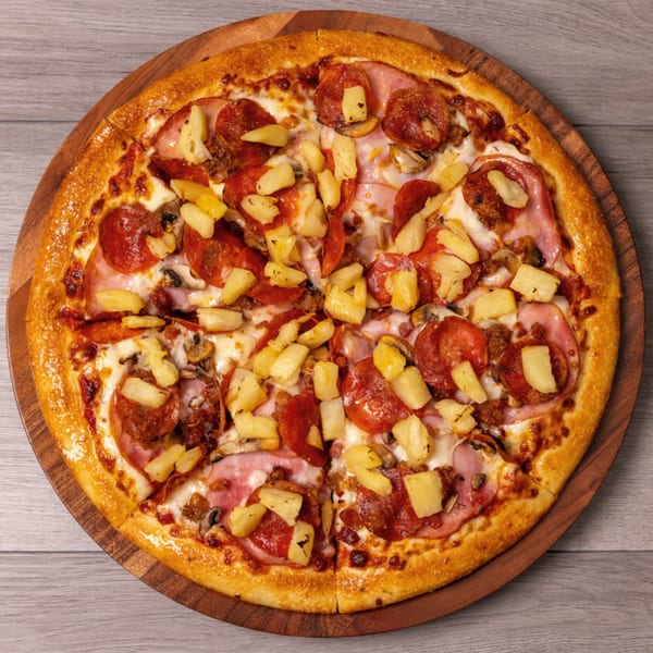 Can Am Pizza's Hawaiian pizza with pepperoni, ham, mushrooms, and pineapple on a wooden board.