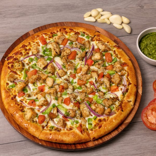 Can Am Pizza's chicken pizza with red onions, green peppers, and tomatoes on a wooden board.