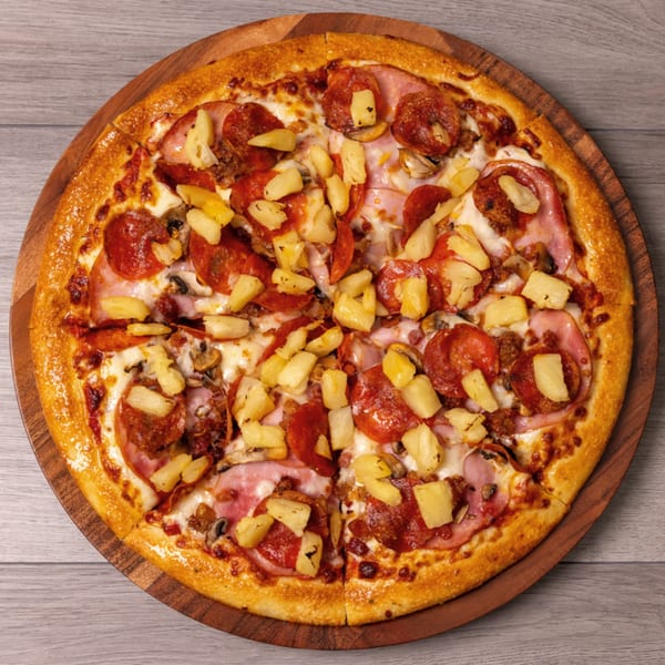 Can Am Pizza's pepperoni, ham, mushroom, and pineapple pizza on a wooden board.
